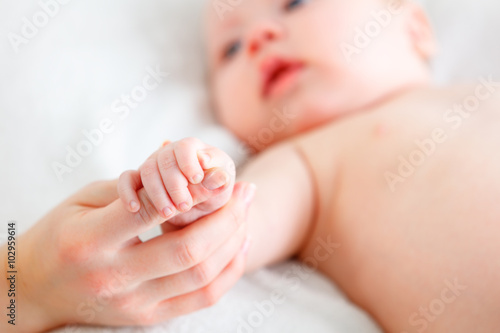 concept of parental love. baby hand holding finger of mother