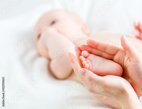 feet newborn baby in arms him mother