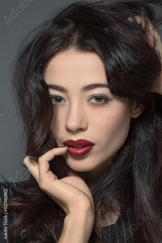 Fashion model woman with dark red lips in studio