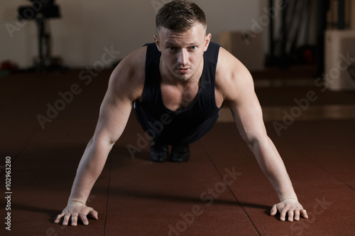 The athlete doing push-up in gym