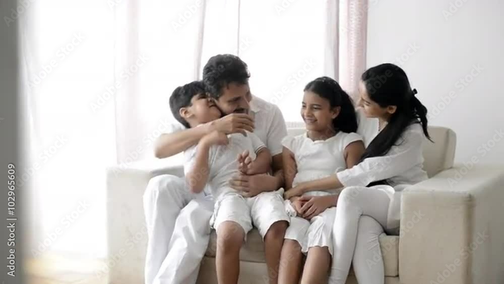 Pan shot of a family enjoying on a couch Pan shot of a family enjoying on a couch