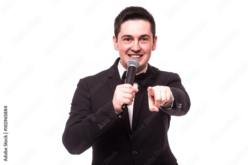 Young elegant talking man holding microphone talking with pointing finger. Isolated on white background. Showman concept. Young elegant talking man holding microphone talking with pointing finger. Isolated on white background. Showman concept.