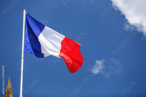 Obraz na płótnie French flag against blue cloudy sky.