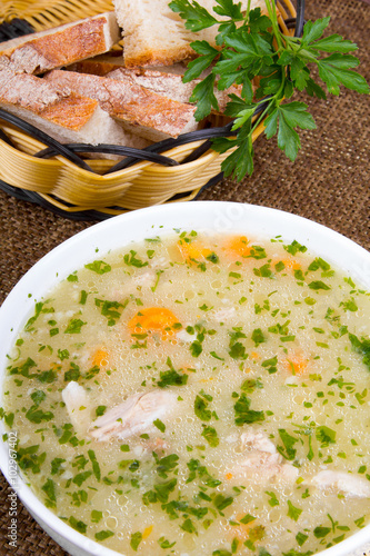 traditional barley soup with meat in a white bowl photo