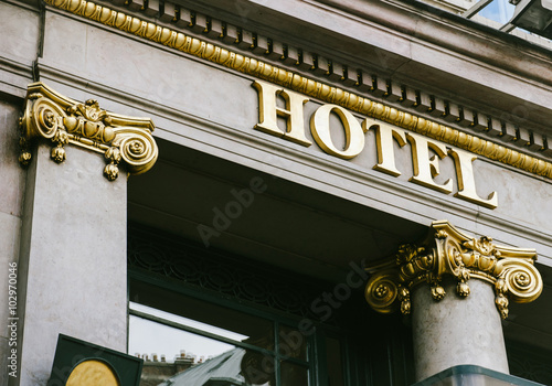 Hotel word with golden letters on beautiful facade with golden columns 