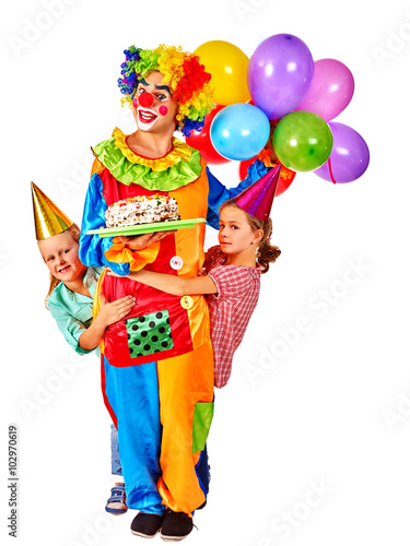 Clown keeps bunch of balloons and birthday cake with group children. Isolated.