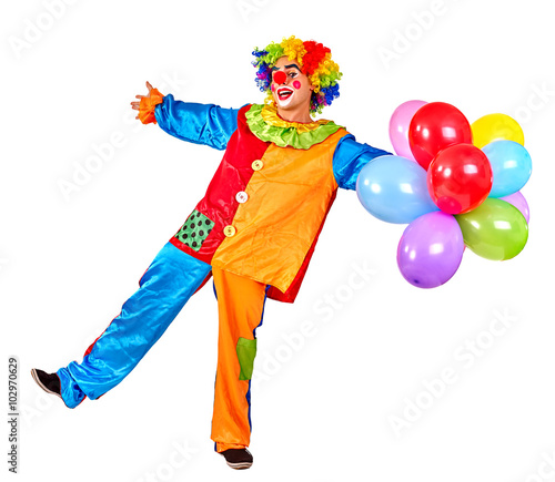 Happy cheerful birthday clown keeps bunch of balloons and is dancing. Isolated.