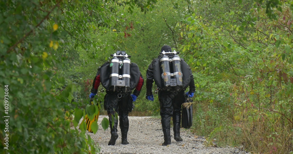 Two Men Divers in Swimsuits Are Walking Away by the Footpath Green Trees along the Footpath Divers are Going to Dive Finished the Diving Outdoors Fall Two Men Divers in Swimsuits Are Walking Away by the Footpath Green Trees along the Footpath Divers are Going to Dive Finished the Diving Outdoors Fall