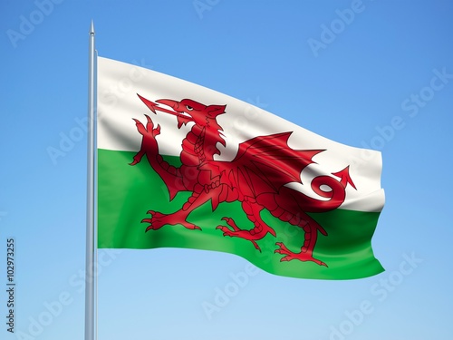 Wales 3d flag floating in the wind with a blue sky background