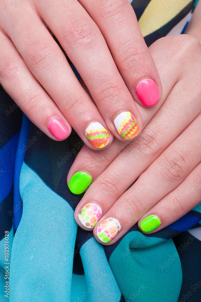 Female hands with multicolored manicure on the background blue handkerchief
Female hands with multicolored manicure on the background blue handkerchief