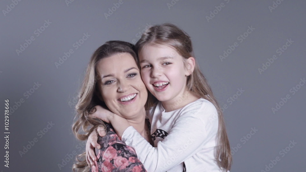 Beautiful and happy young mother with a small 8 years daughter in studio. Beautiful and happy young mother with a small 8 years daughter in studio.