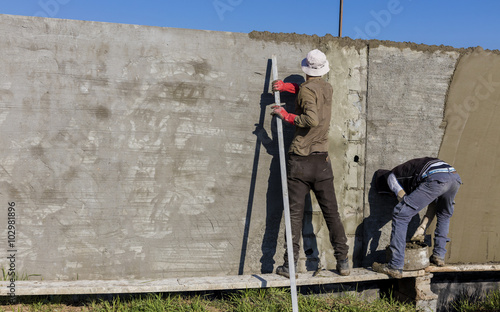 Iraqi Arab worker in project working in plastering of new constructed wall in Iraqi desert at winter season