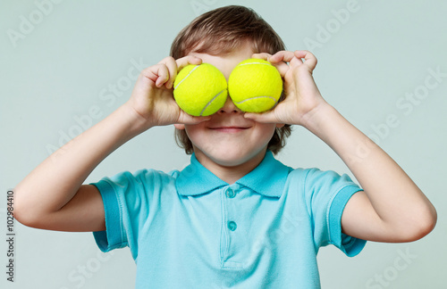  Little boy holding tennis balls instead of the eyes, smiling © zdyma4