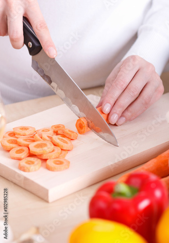 Close-up of female cutting vegetables on a kitchen cutting board