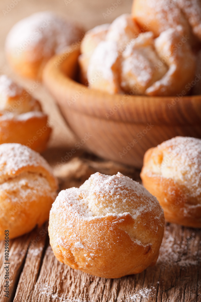 Festive Italian donuts Castagnole close up in a bowl. vertical
