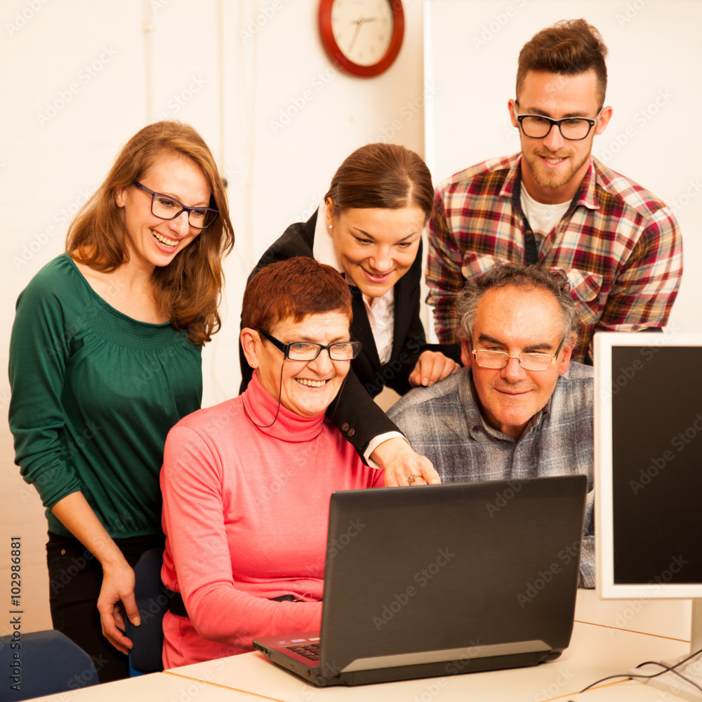 Group of adults learning computer skills. Intergenerational tran Group of adults learning computer skills. Intergenerational tran