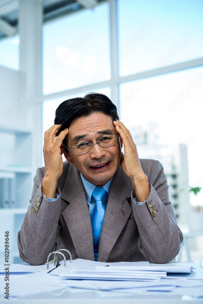 Worried businessman working at his desk Worried businessman working at his desk