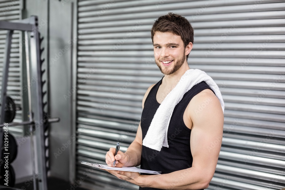 Fototapeta premium Trainer taking notes at crossfit gym