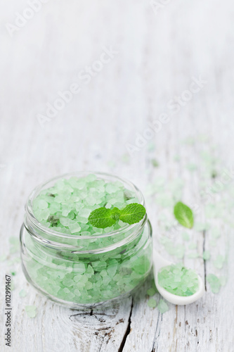 Sea salt bath scented mint for spa and aromatherapy on white wooden background, rustic style