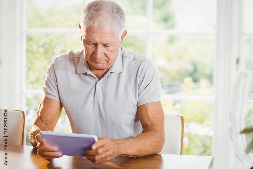 Focused senior man using tablet Focused senior man using tablet