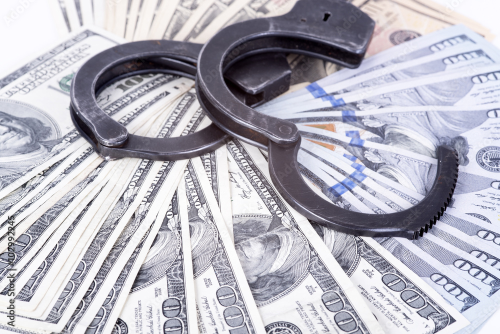 Crime and Money. Handcuffs are on the dollar Crime and Money. Handcuffs are on the dollar