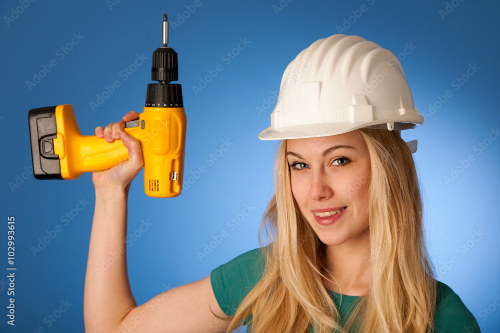 Woman with constructor helmet and electric wrench happy to do to Woman with constructor helmet and electric wrench happy to do to