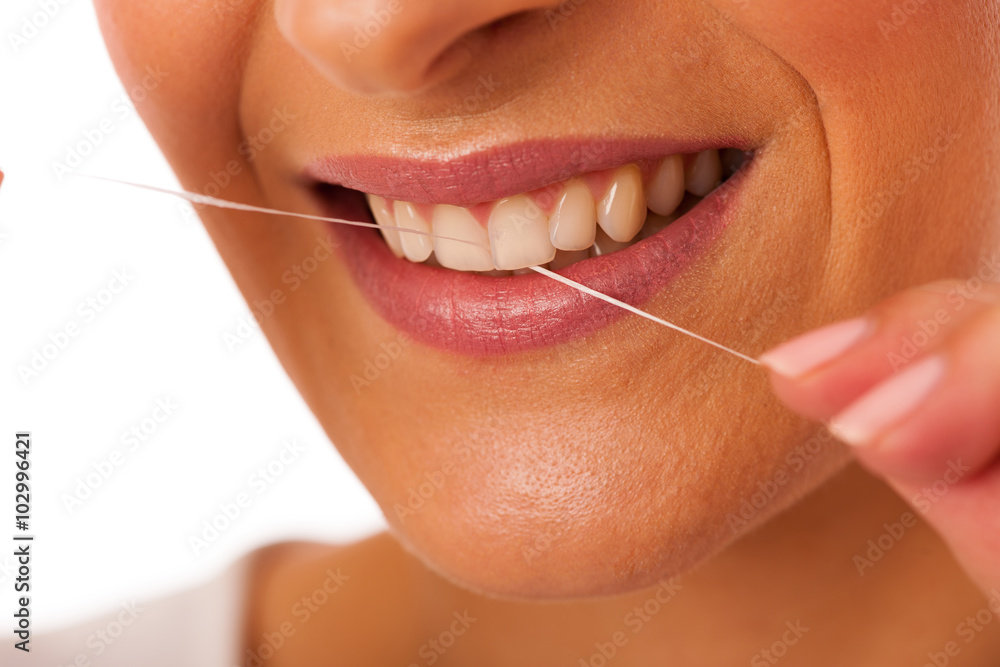 Obraz premium Woman cleaning teeth with dental floss for perfect hygiene and h