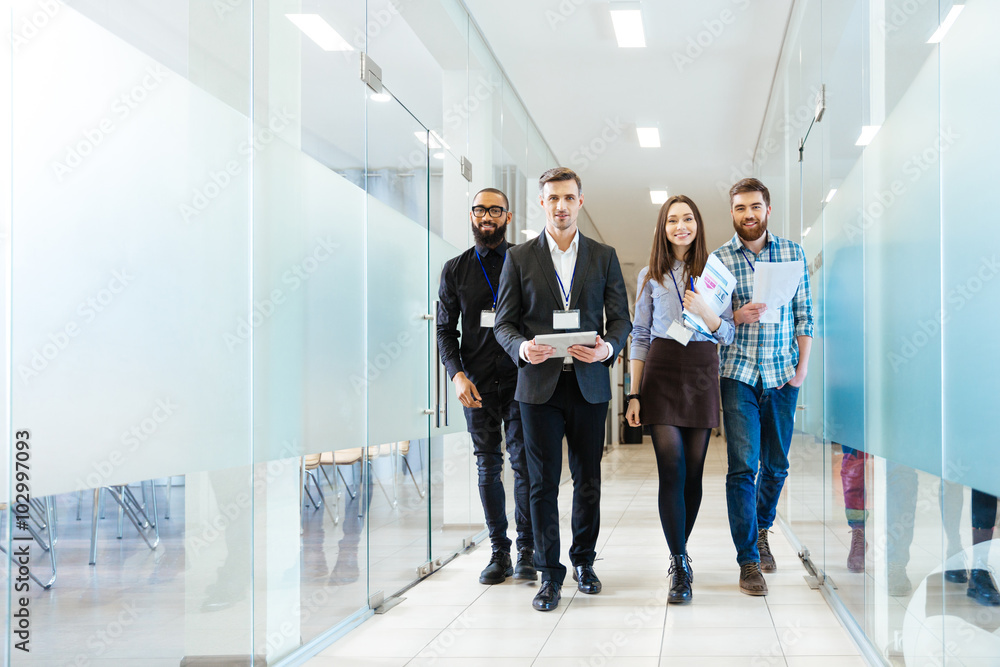 Obraz premium Group of happy young business people walking in office together