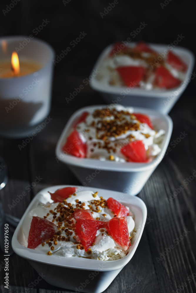 Delicious breakfast of useful products . Bee pollen with cottage cheese , sour cream and grapefruit . Delicious breakfast of useful products . Bee pollen with cottage cheese , sour cream and grapefruit .