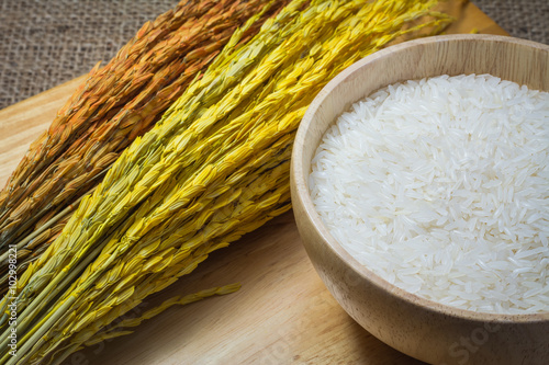 Rice in wooden bowl on Sack or wood table background