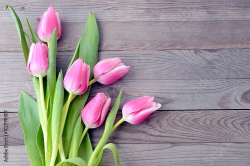 Fototapeta Naklejka Na Ścianę i Meble -  Pink tulips on wooden table.