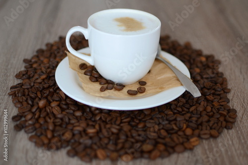 cup of cappuicco and coffee beans
