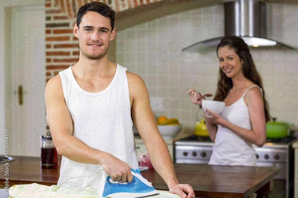 Portrait of man ironing a shirt in kitchen Portrait of man ironing a shirt in kitchen