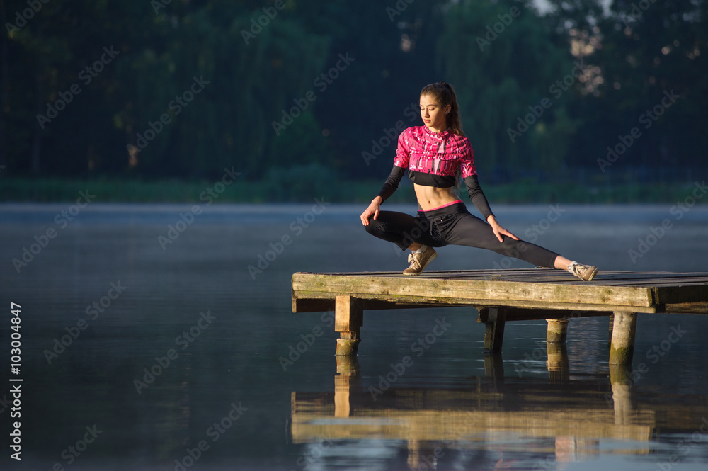 young woman doing exercises on the lake