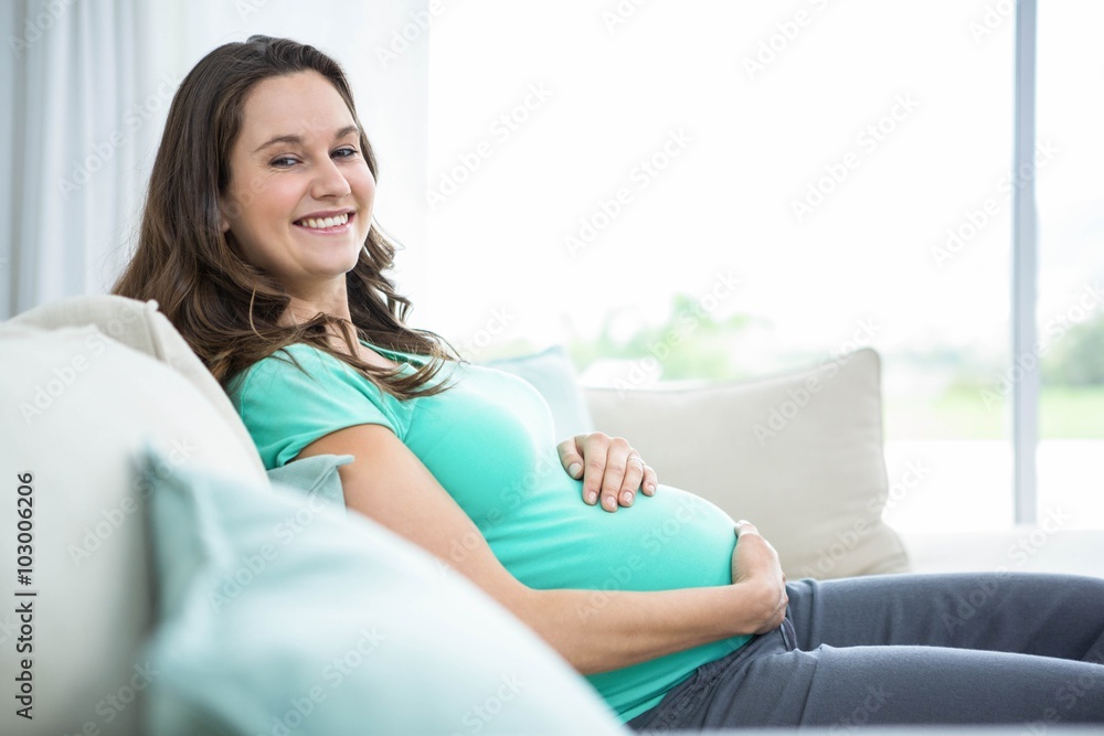 Pregnant woman sitting on couch Pregnant woman sitting on couch