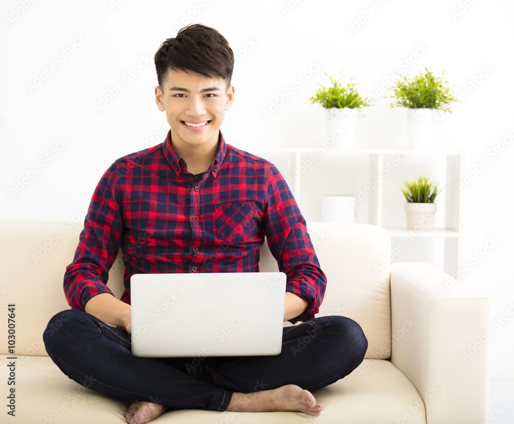 happy Young man relaxing on the sofa with laptop happy Young man relaxing on the sofa with laptop