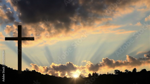 One Christian cross on a hill at sunset photo