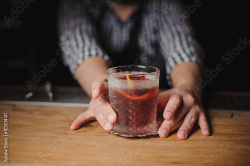 Barman at work, serving cocktails.