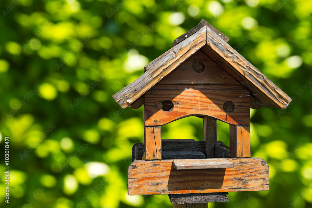 Old wooden birdhouse on a green blurred background Old wooden birdhouse on a green blurred background