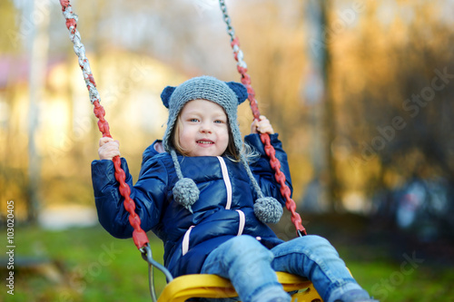 Cute little girl having fun on a swing