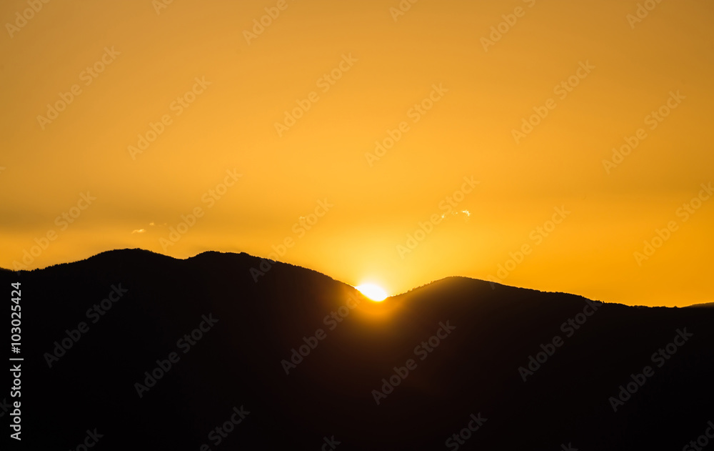 Majestic vivid sunset/sunrise over dark mountains silhouettes