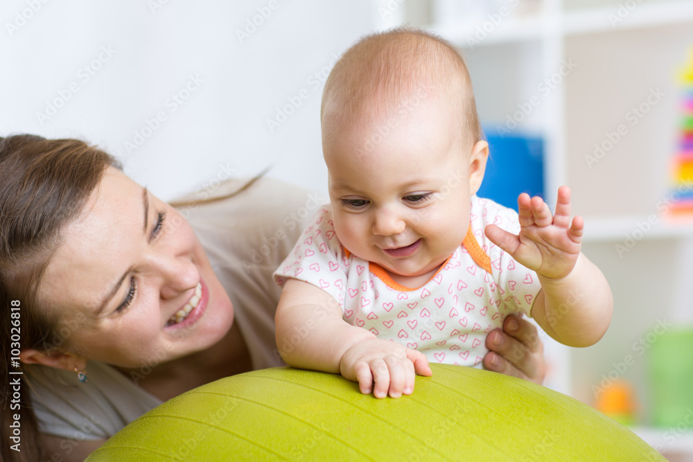 Portrait of happy mother and her baby in gym Portrait of happy mother and her baby in gym