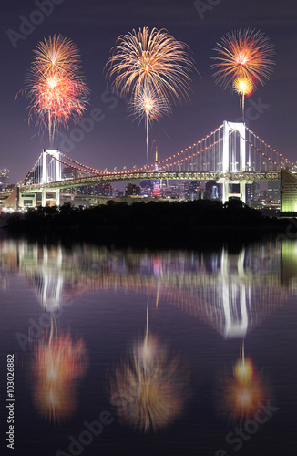 Fireworks celebrating over Tokyo Rainbow Bridge with mirror refl
