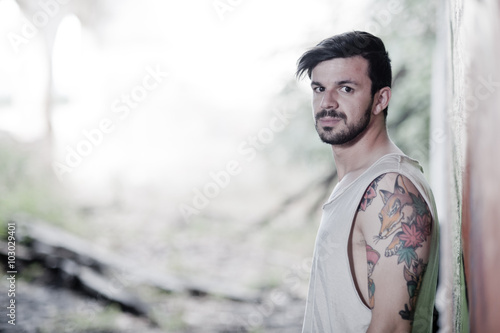 Adolescente tatuado con rostro serio