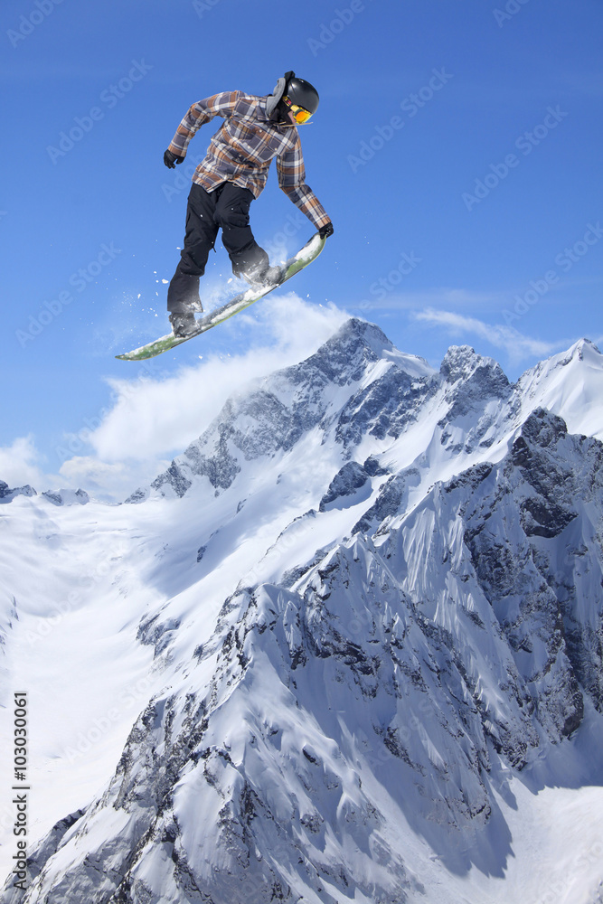 Flying snowboarder on mountains. Extreme sport.