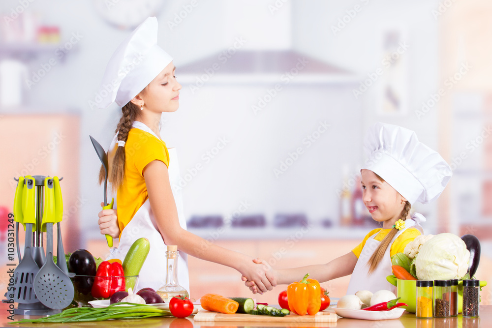 Two cheerful little chefs shake hands Two cheerful little chefs shake hands