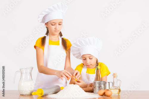 two little chef's in the kitchen playing cook out flour