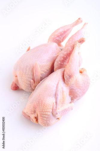 raw quail with lemon and spices on a white background