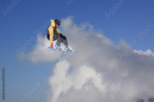 Flying snowboarder on mountains. Extreme sport.