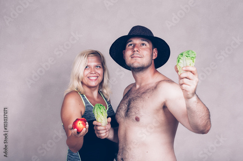 Fotografie Happy corpulent couple with fruit and vegetable